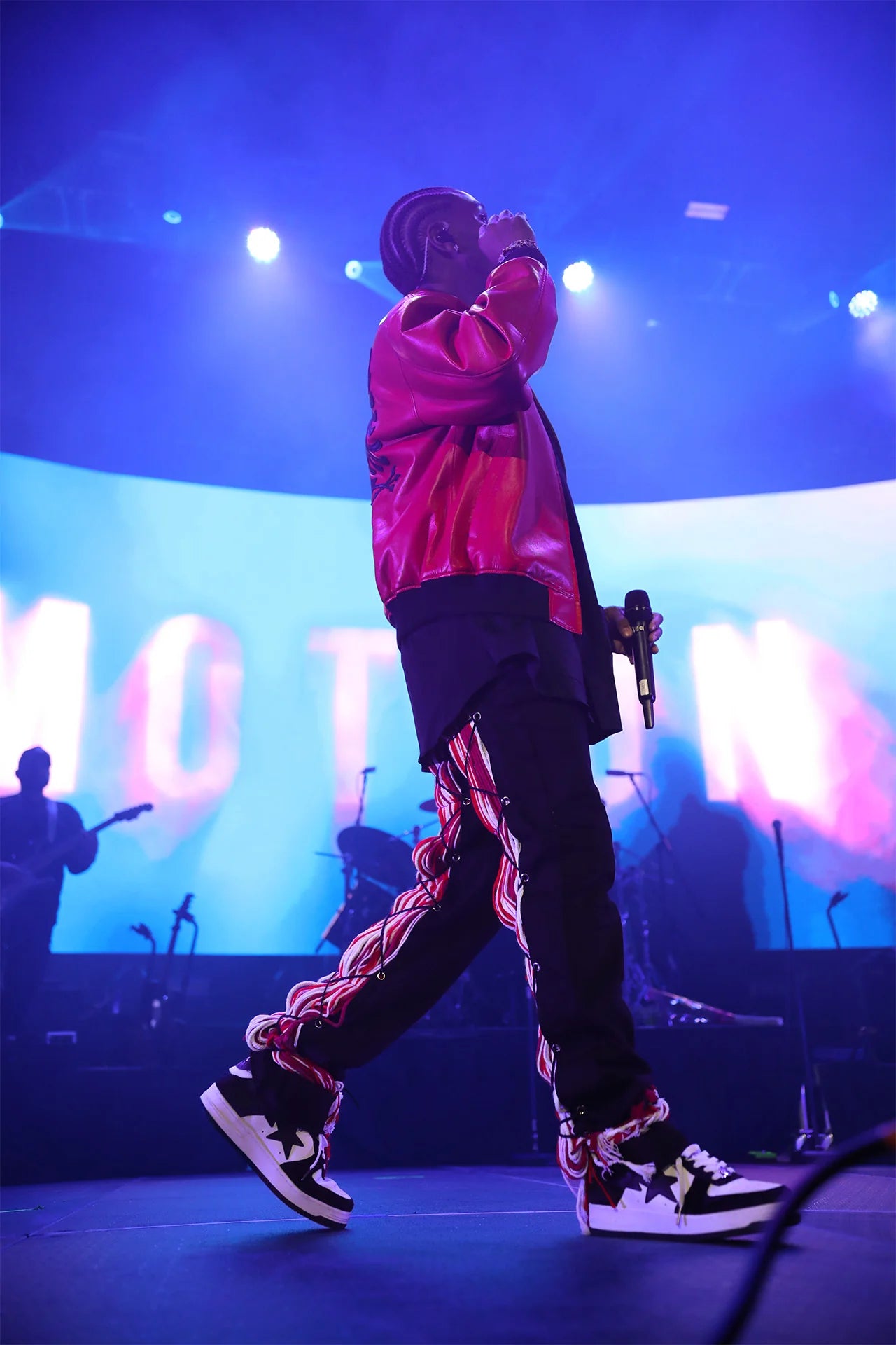 A singer performing in a stage wearing a Red Leather Jacket