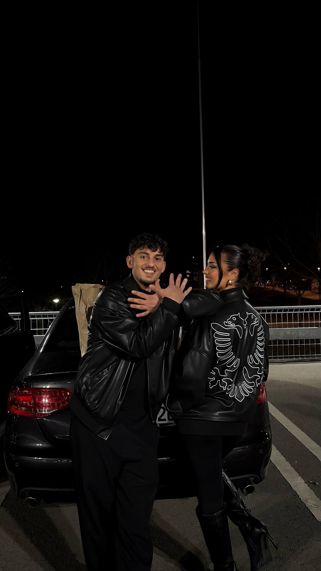 Couple wearing Hajde Zemer Albanian eagle leather jackets at night