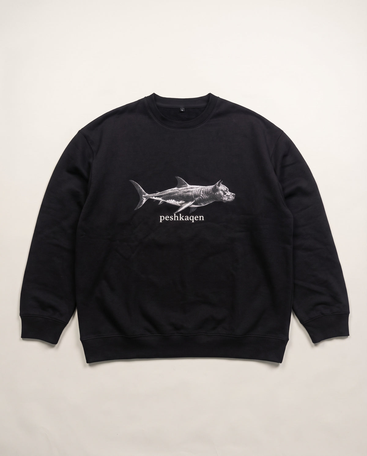 Hajde Zemer Peshkaqen Longsleeve in black — front, white shark-dog graphic with peshkaqen lettering at the chest