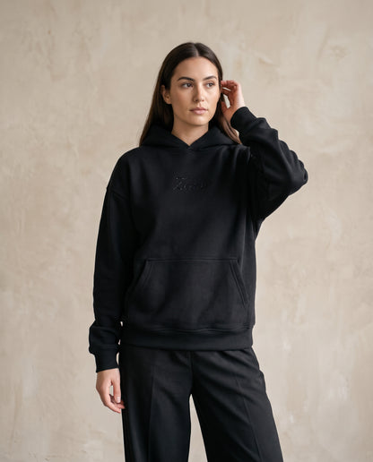 Eagle Rhinestone Hoodie in black, worn front view on a female model - black rhinestone Zemer script at the chest