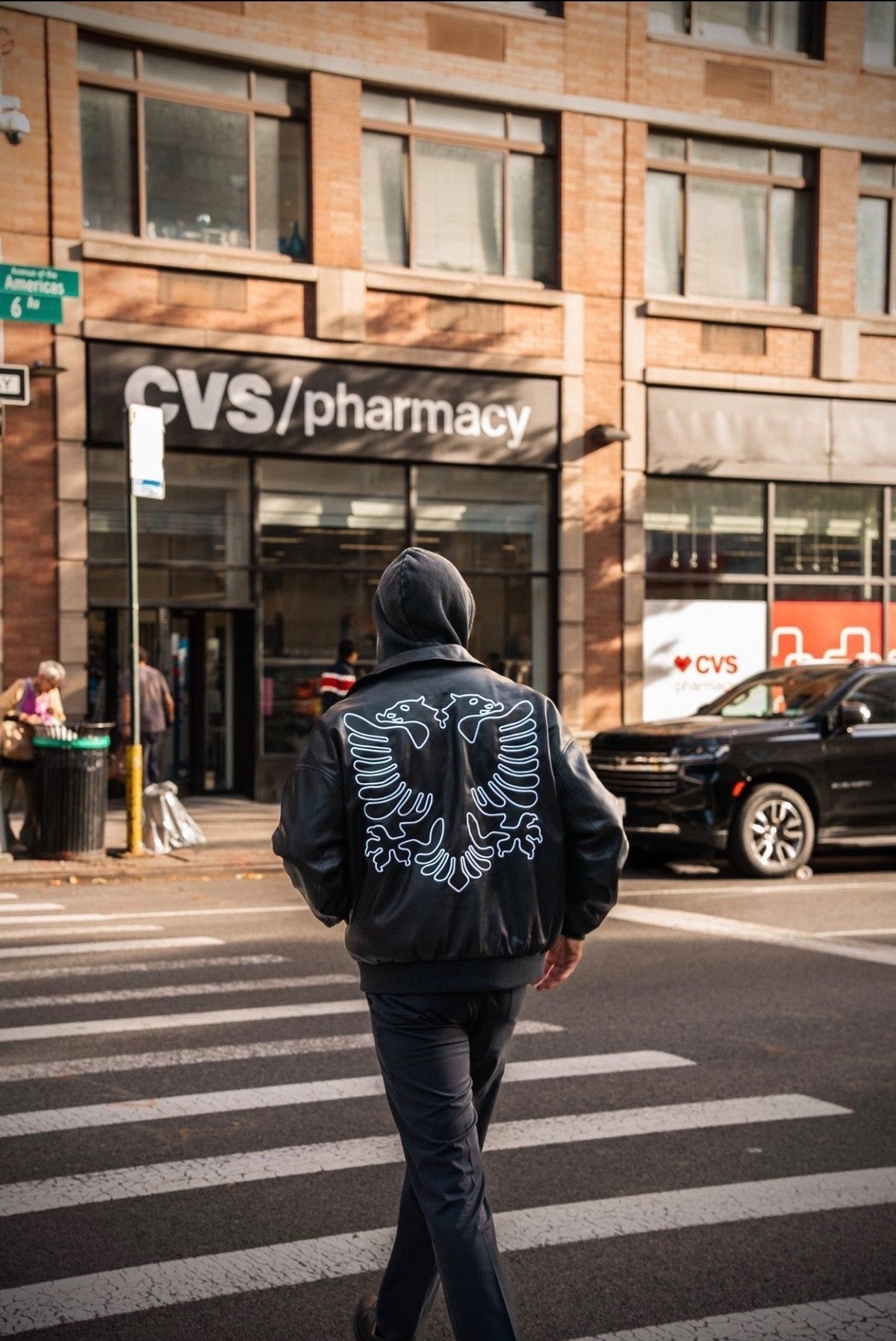 Albanian Black Eagle Jacket — model wearing jacket on city street, front view