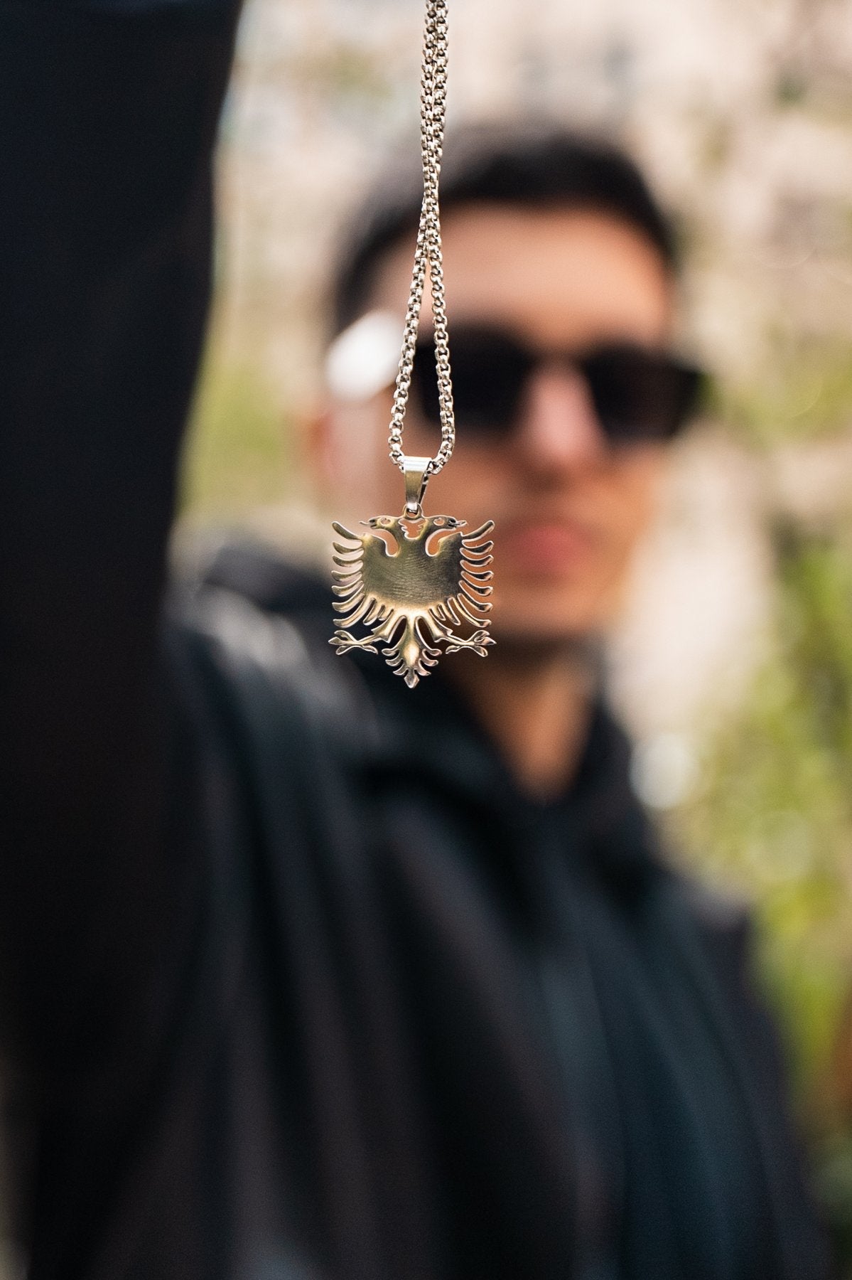 Albanian Eagle Pendant Necklace — close-up worn view, person holding pendant