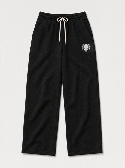 Design preview: Hajde Zemer HZ Essential Eagle Sweatpants in black, front flat lay with the cream double-headed eagle at one hip