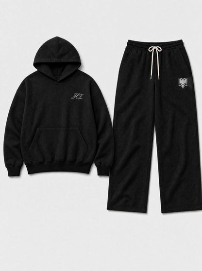 Design preview: Hajde Zemer HZ Essential Eagle Set in black, hoodie and sweatpants laid side by side, cream eagle at the pant hip