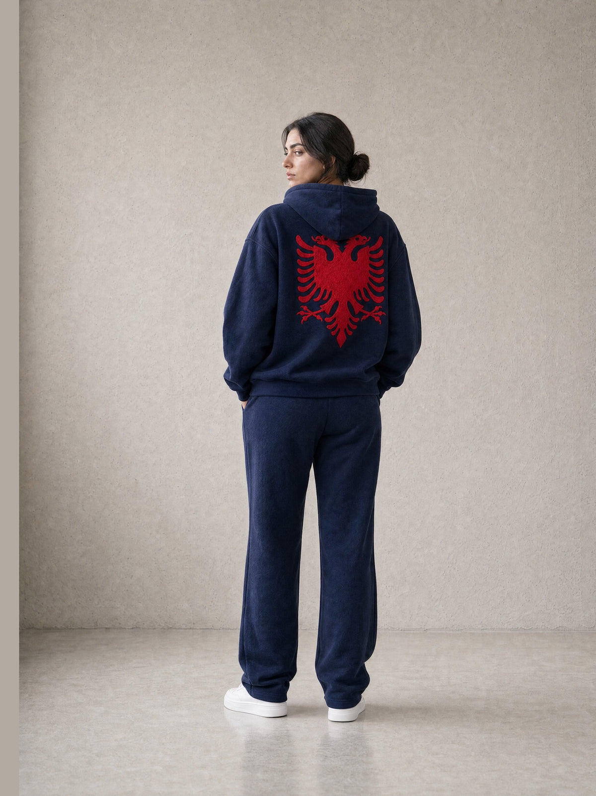 Design preview: Hajde Zemer HZ Essential Eagle Set in blue navy, back view on a female model, red Albanian eagle across the hoodie