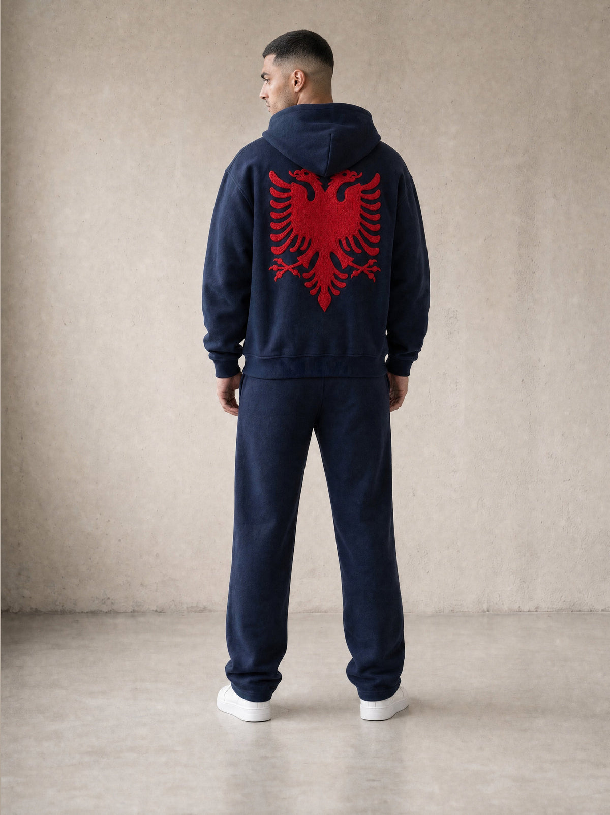 Design preview: Hajde Zemer HZ Essential Eagle Set in blue navy, back view on a male model, red Albanian eagle across the hoodie