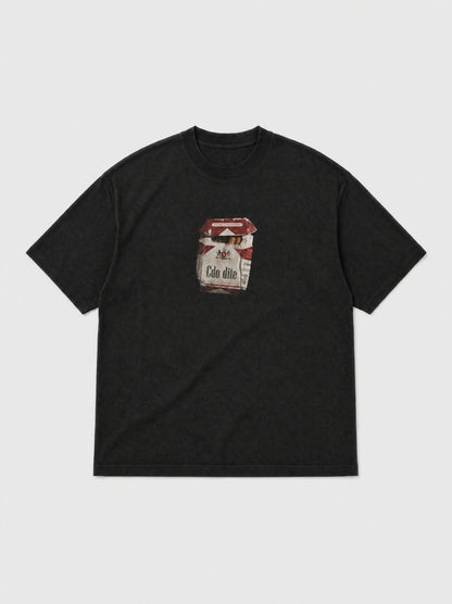 Hajde Zemer black tee laid flat, front view, small printed cigarette packet graphic on the chest