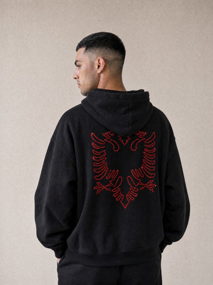 Man wearing the black Hajde Zemer Essential Eagle hoodie, back view, red outline Albanian eagle across the back