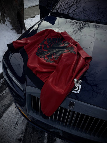 Albanian Red Eagle Jacket draped on Rolls Royce hood in winter — luxury lifestyle social media shot | Hajde Zemer
