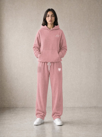 Design preview: Hajde Zemer HZ Essential Eagle Set in dusty rose pink, front view on a female model - cream HZ script on the chest, cream double-headed eagle at the sweatpant hip